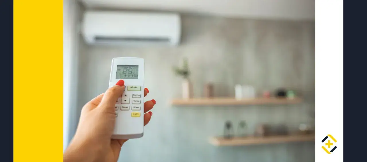 Mano con mando a distancia de aire acondicionado, ajustando la temperatura. Ideal para calcular potencia aire acondicionado y optimizar el confort.