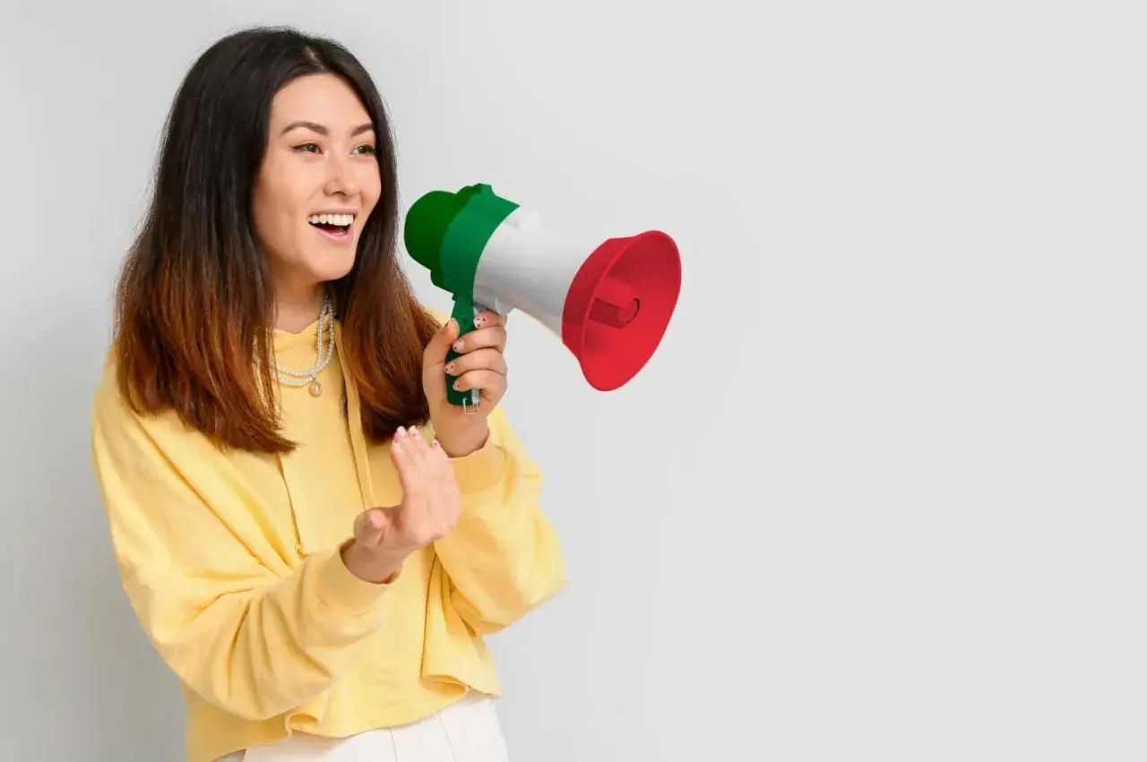 Ragazza con megafono tricolore italiano, che annuncia "mercoledì in inglese pronuncia" con entusiasmo.