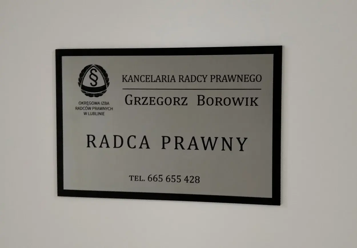Tabliczka z napisem "Kancelaria Radcy Prawnego Grzegorz Borowik", z logo i numerem telefonu.
