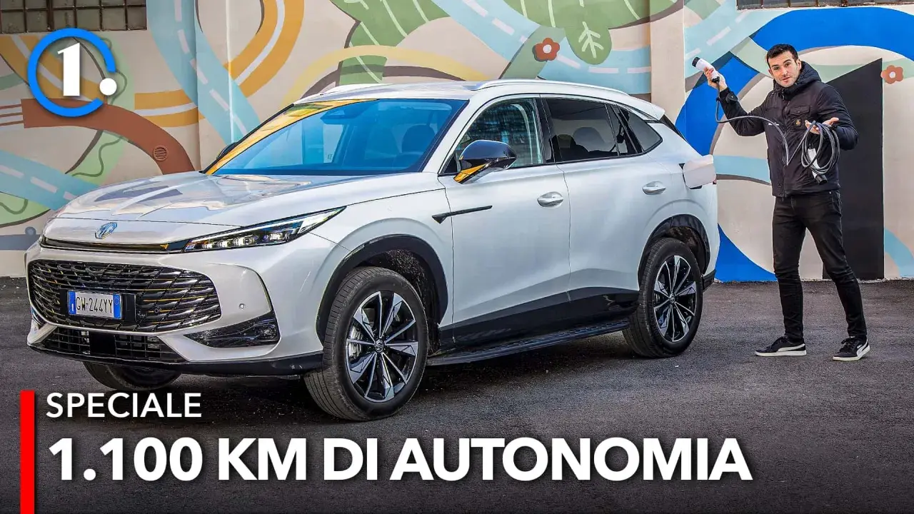 Un uomo con cavo di ricarica accanto a un MG HS Hybrid+ bianco, pronto per un viaggio di 1.100 km.