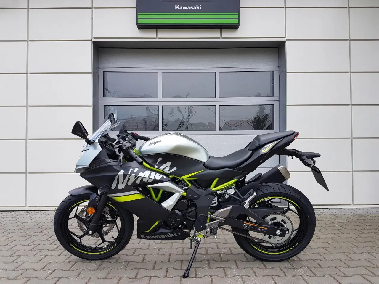 Czarny Kawasaki Ninja 125 z neonowo-zielonymi akcentami, gotowy do osiągnięcia swojej prędkości maksymalnej.