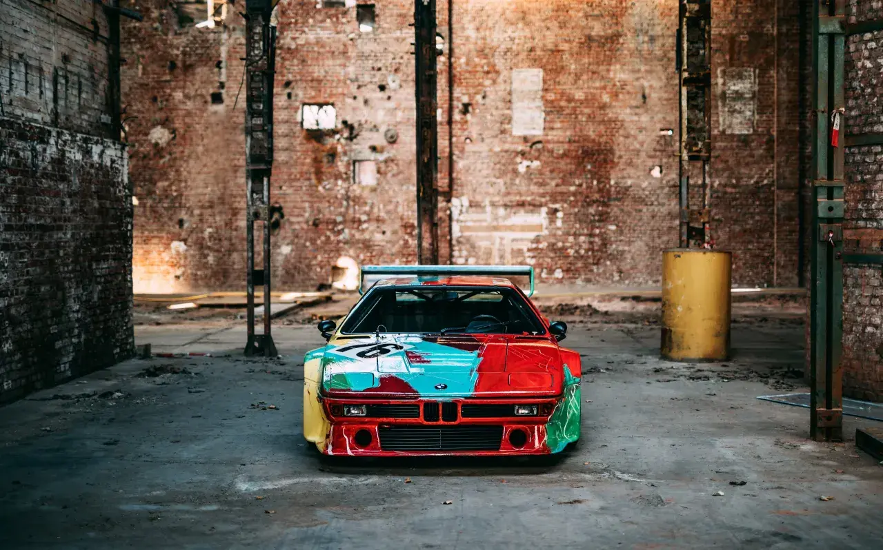 Kultowe BMW M1 w artystycznym malowaniu, stojące w opuszczonej fabryce.