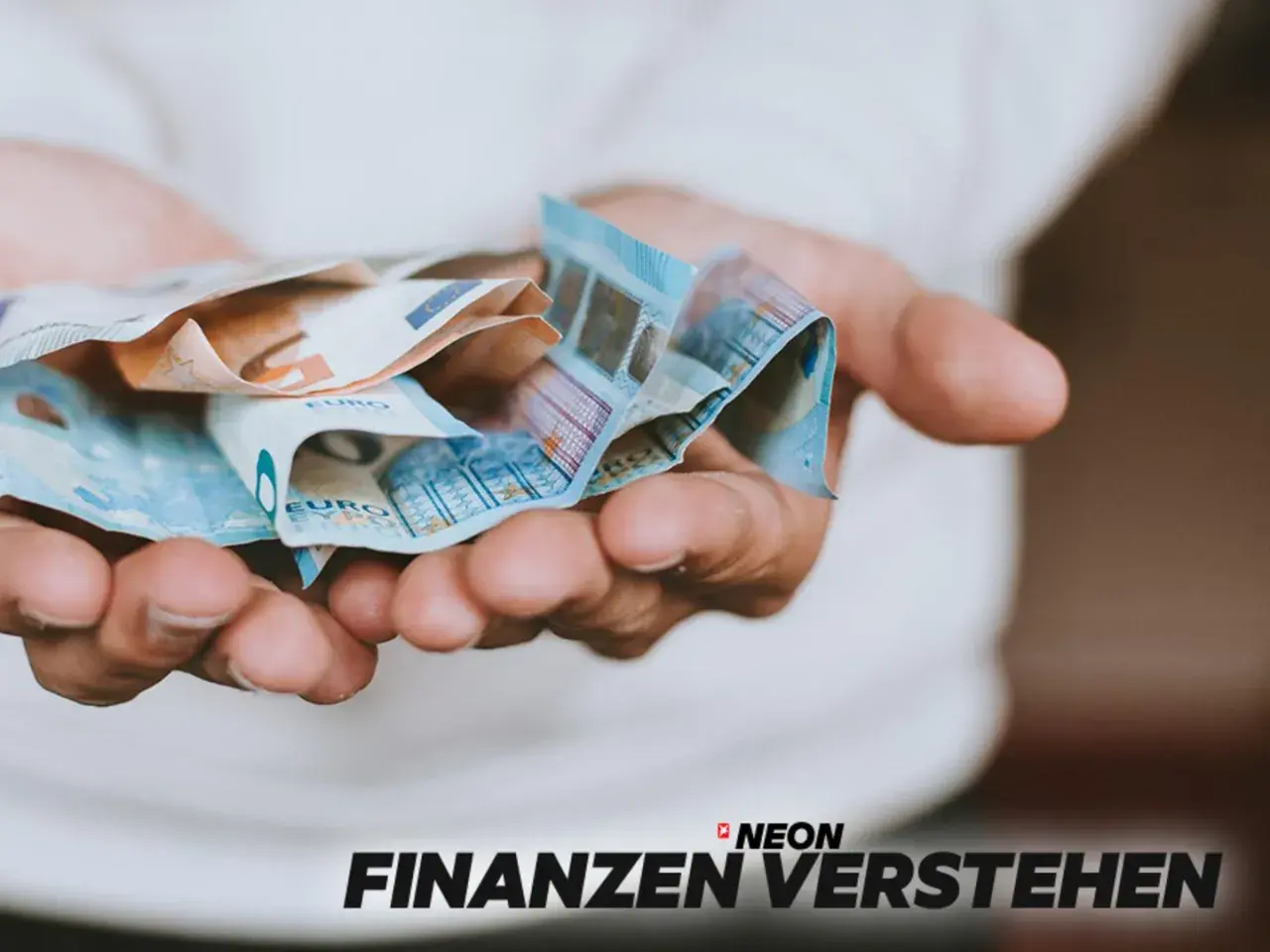 Hände halten Euro-Scheine. So können Sie Ihre **monatlichen Kosten senken** und mehr Geld sparen.