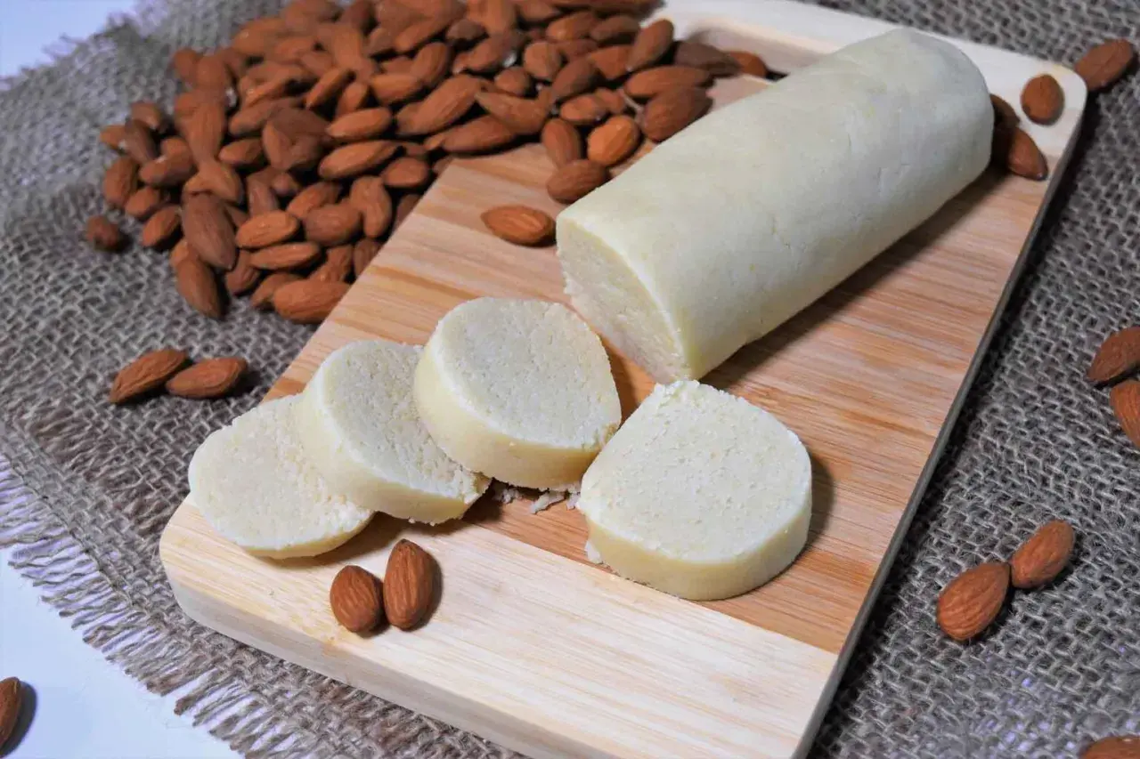 Frisch zubereitetes Marzipan, bereit zum **Marzipan selber machen**. Mandeln und Marzipanrolle auf Holzbrett.