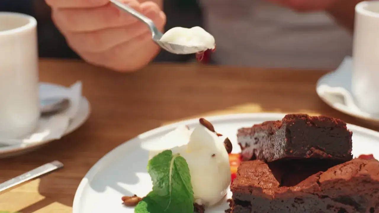 Słodki deser z brownie i lodami, serwowany w pomelo bistro. Idealny na popołudniową kawę.