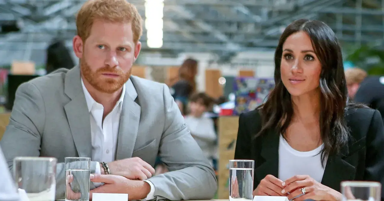 Meghan i Harry siedzą przy stole, rozmawiając.