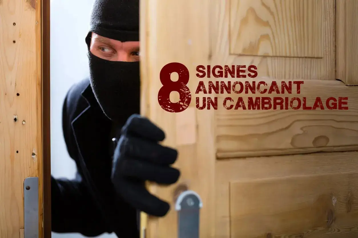Un cambrioleur masqué, vêtu de noir, jette un regard furtif par une porte entrouverte. Le texte "8 signes annonçant un cambriolage" est visible.