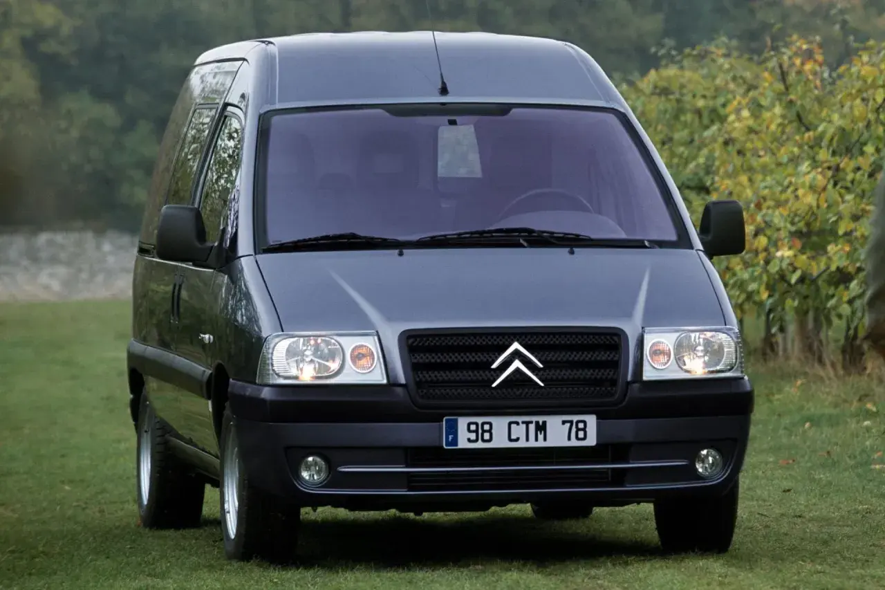 Szary Citroen Jumpy 2.0 HDi na trawie, gotowy na podróż.