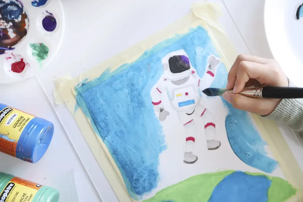 Niño pintando un astronauta en el espacio. Un proyecto de arte en infantil que fomenta la creatividad y la imaginación.