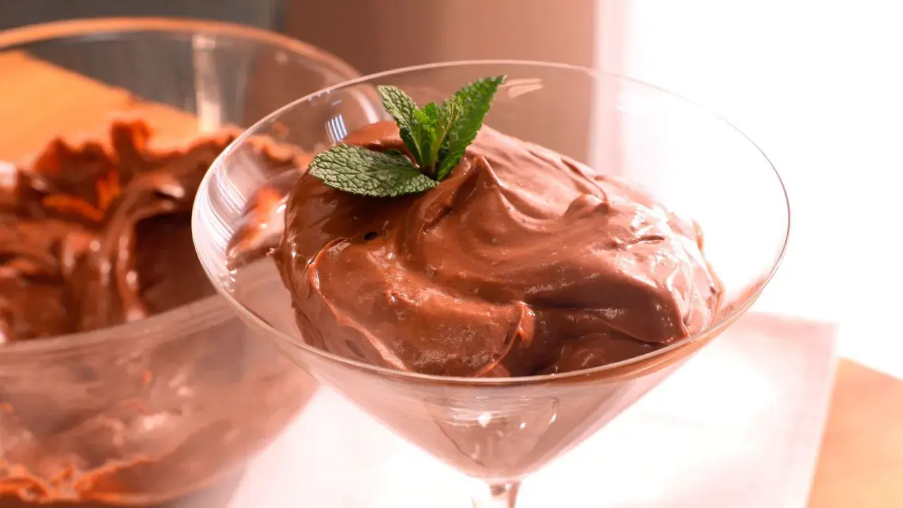 Deliciosa crema de cacao pralin, servida en copa de cóctel y decorada con menta fresca.