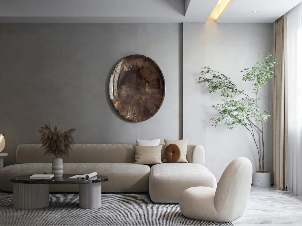 Salon w stylu japońskim skandynawskim. Jasna sofa, okrągły stolik, dekoracyjna taca na ścianie i drzewko bonsai tworzą harmonię.