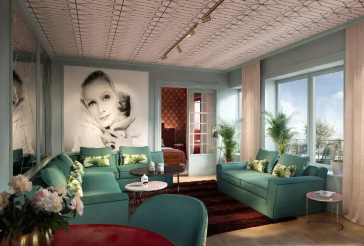 Ett lyxigt vardagsrum i art deco-stil med en stor bild av Greta Garbo, smaragdgröna soffor och ett mönstrat tak. En elegant inredning som andas **art deco Stockholm**.