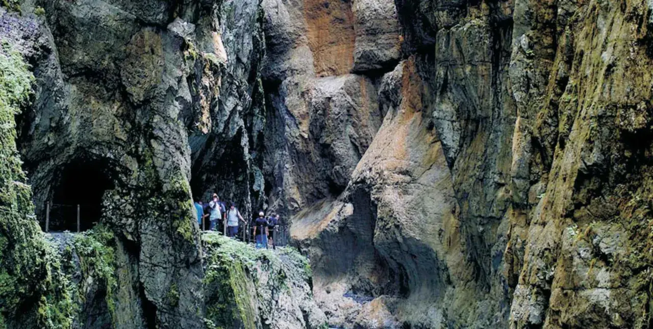 Wanderer erkunden die beeindruckende Klamm Garmisch mit ihren steilen Felswänden und moosbewachsenen Gängen.