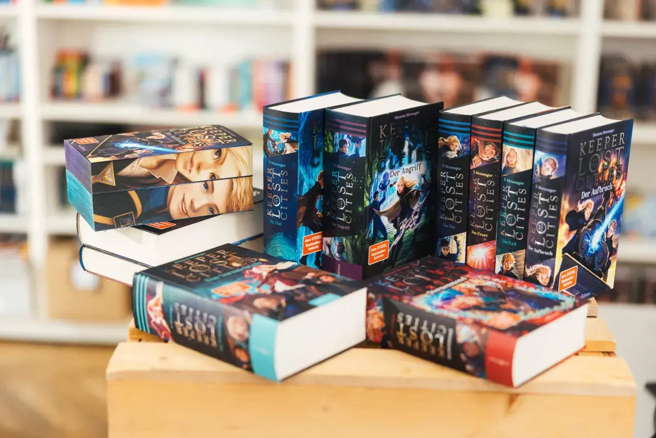 Bücher der Reihe "Keeper of the Lost Cities" in deutscher Reihenfolge, gestapelt und nebeneinander.