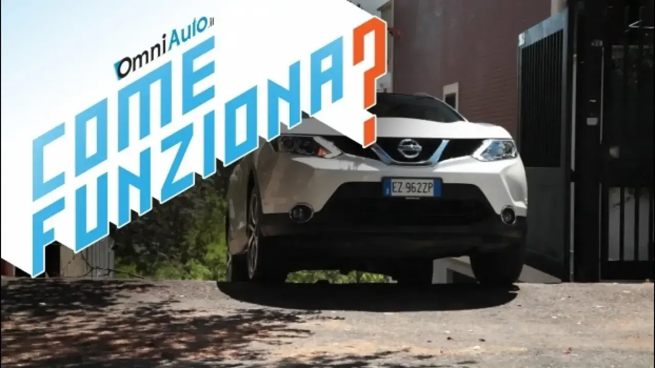 Nissan bianco su strada in salita, con testo "Come funziona?". Spiegazione del sistema hill holder.