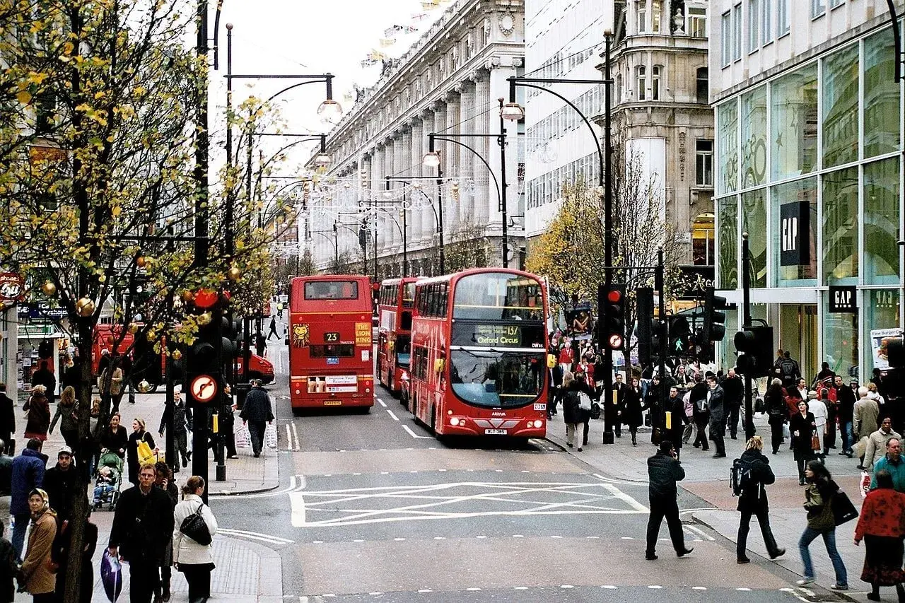Tłum ludzi i czerwone piętrowe autobusy na najsłynniejszej ulicy w Londynie, Oxford Street.