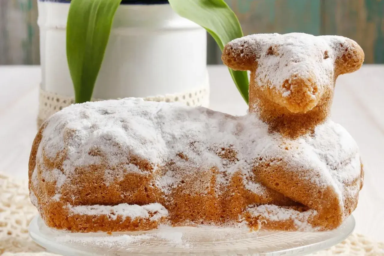Ein süßer Osterlamm-Kuchen, mit Puderzucker bestäubt, symbolisiert die Bedeutung von Ostern und Neuanfang.