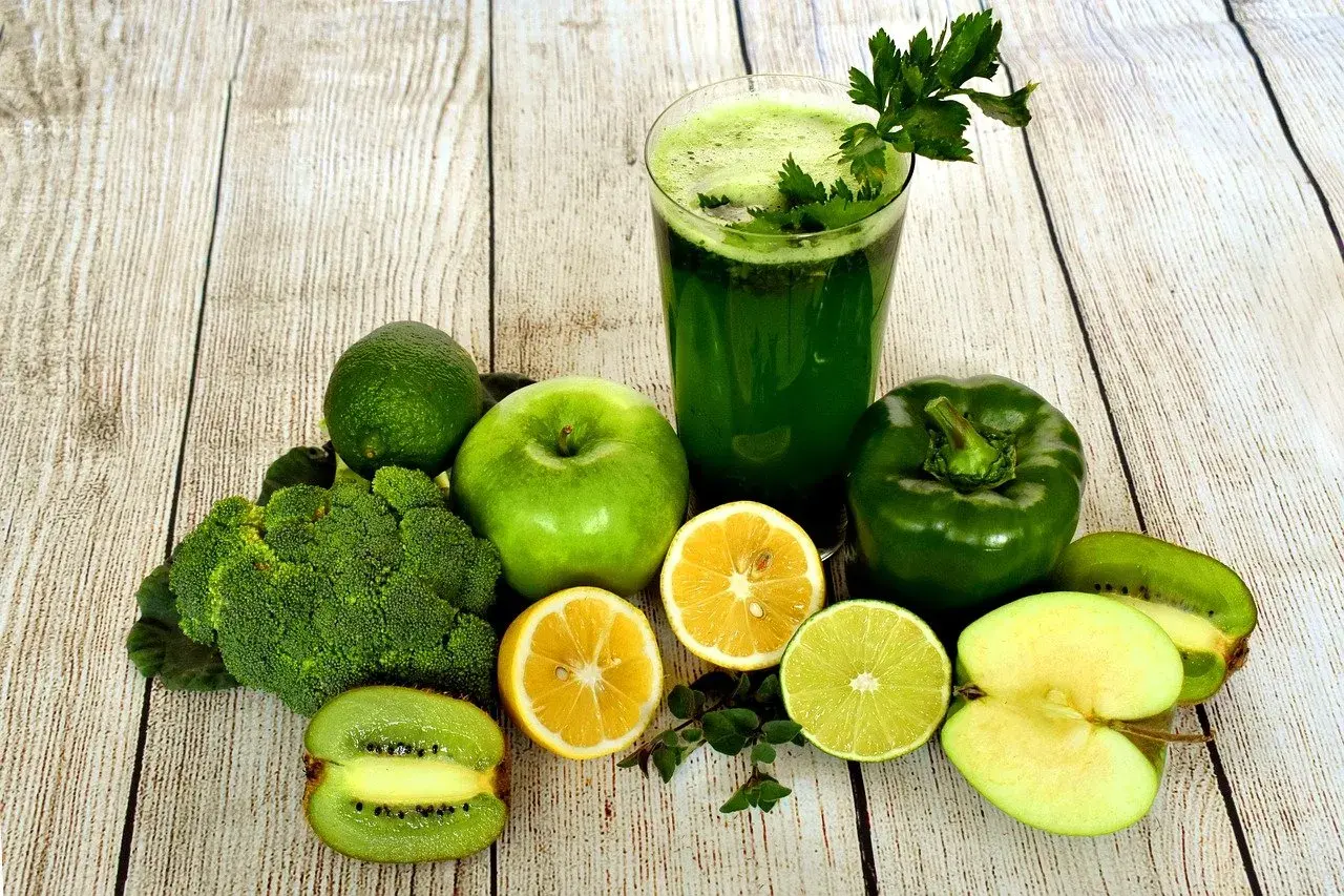 Zielony koktajl i świeże warzywa oraz owoce: brokuły, jabłka, kiwi, cytryny, limonka, papryka. Idealne składniki, by dowiedzieć się, jak oczyścić jelita.