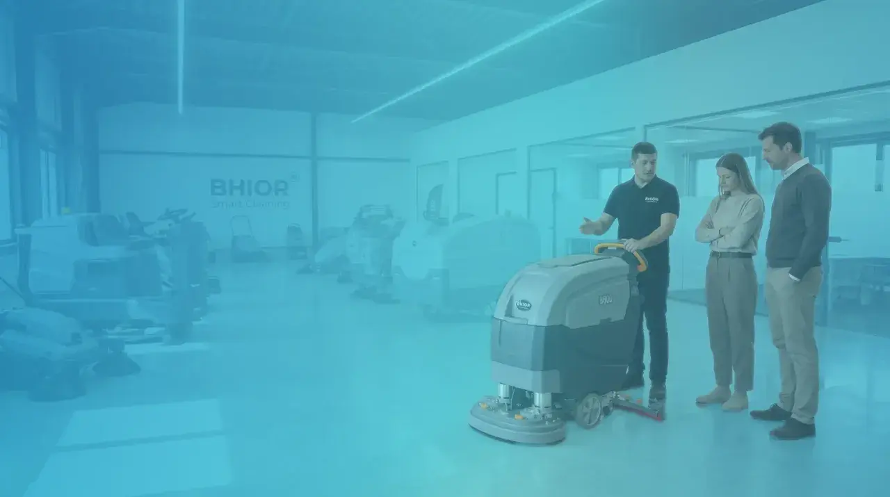 Un vendedor muestra equipos de limpieza industrial a dos clientes.