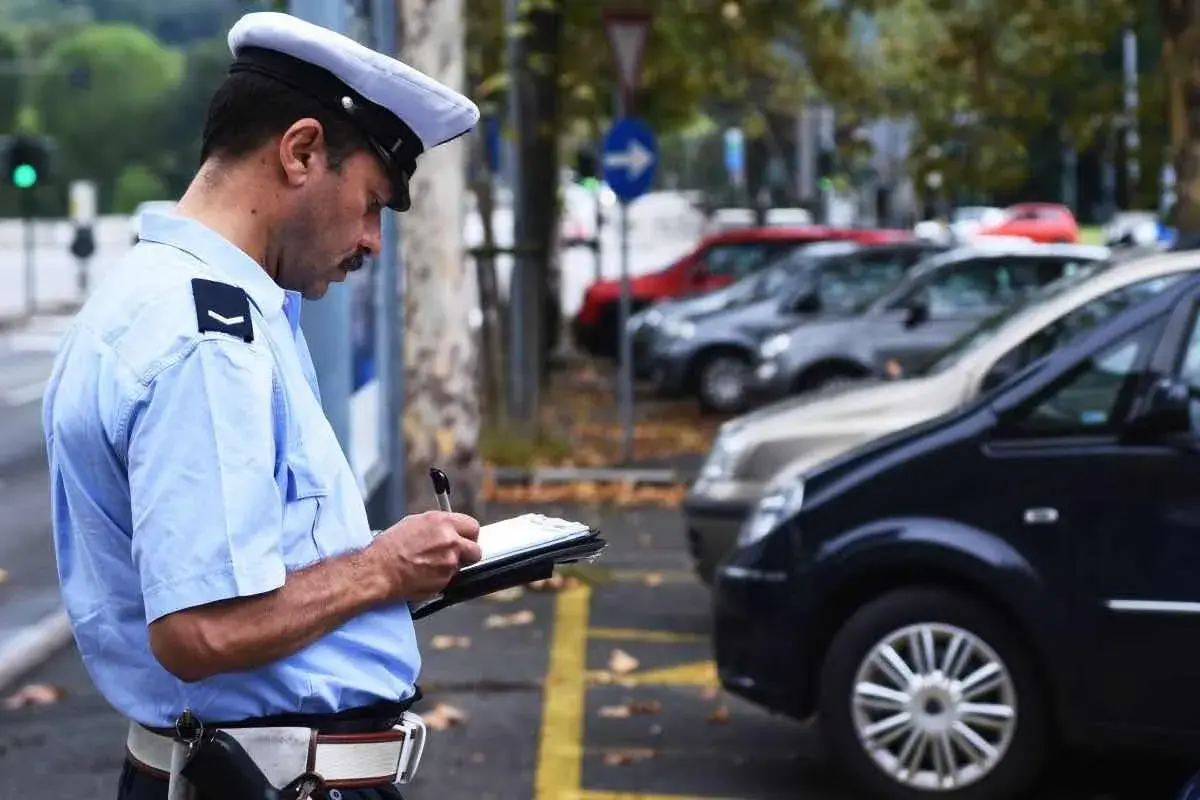 Agente di polizia scrive una multa. Cosa succede se non pago una multa? Potrebbe comportare sanzioni aggiuntive e problemi legali.