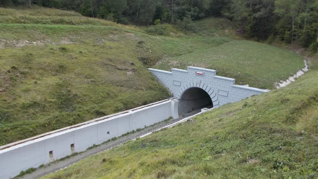 Nowy tunel kolejowy na przełęczy łupkowskiej, wcinający się w zielone zbocze.