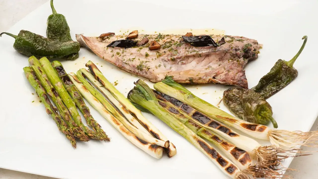 Pescado chicharro a la plancha con espárragos, pimientos de Padrón y cebolletas asadas.