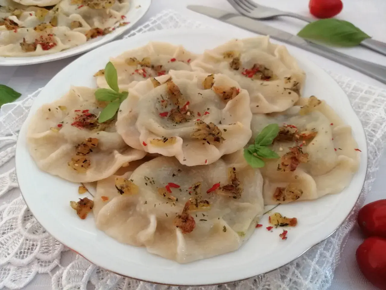 Pyszne pierogi ze szpinakiem, posypane skwarkami i ziołami. Idealne z sosem czosnkowym lub kwaśną śmietaną.
