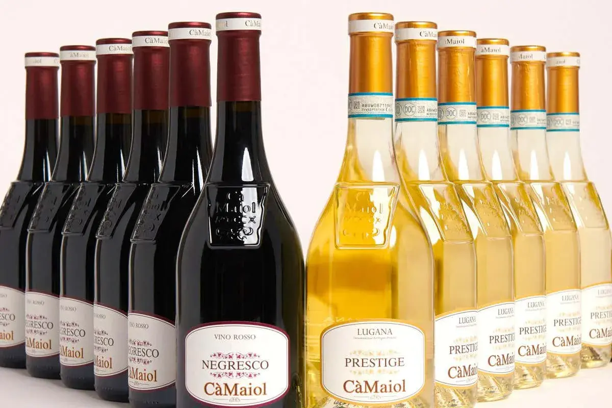 Bottiglie di vino rosso e bianco Cà Maiol Sirmione, con etichette che riportano "Negresco" e "Prestige".