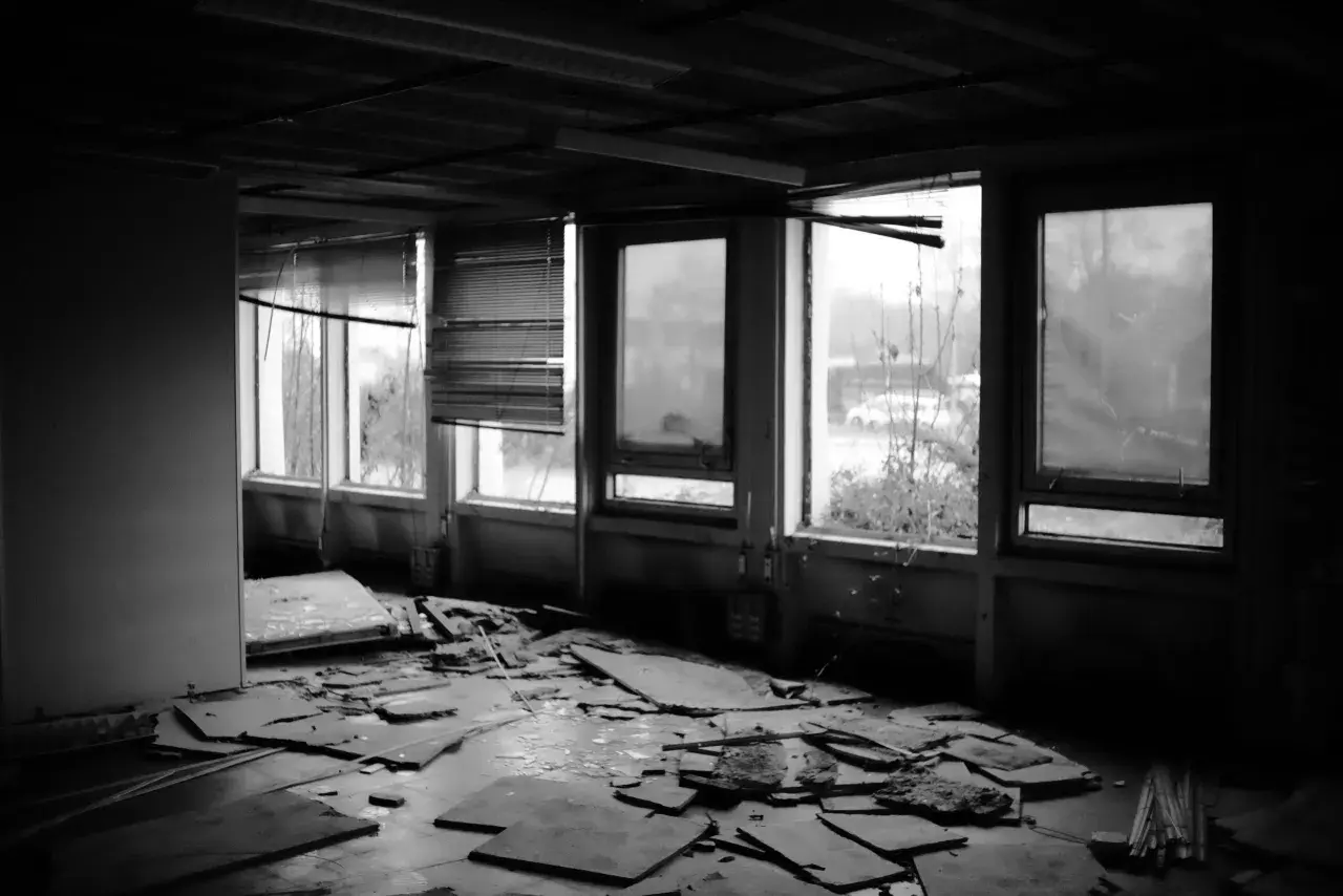 Intérieur dévasté, débris au sol, fenêtres brisées. Une scène typique d'urbex en Mayenne, où le temps a laissé sa marque.