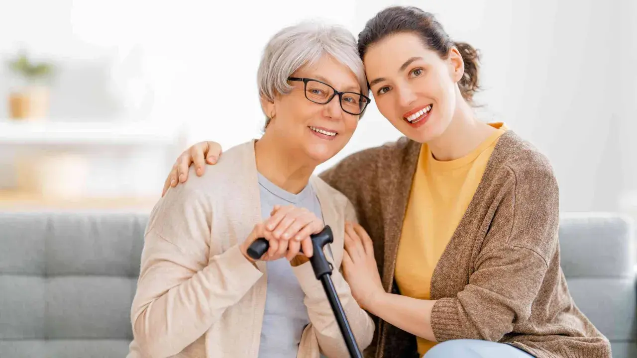 Un modello ap70: due donne sorridono, una anziana con bastone e occhiali, l'altra più giovane con un abbraccio.