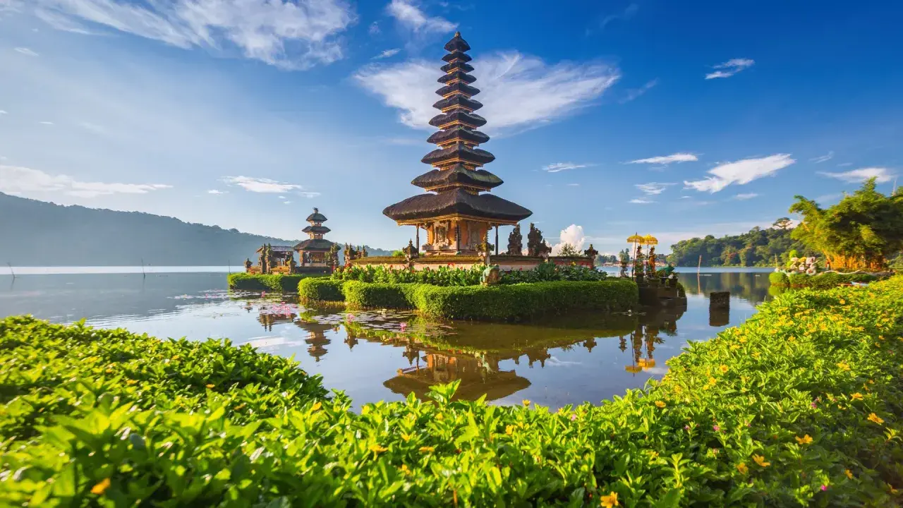 Świątynia Pura Ulun Danu Bratan na Bali, jaki to kraj! Woda odbija wielopoziomową wieżę na tle błękitnego nieba.