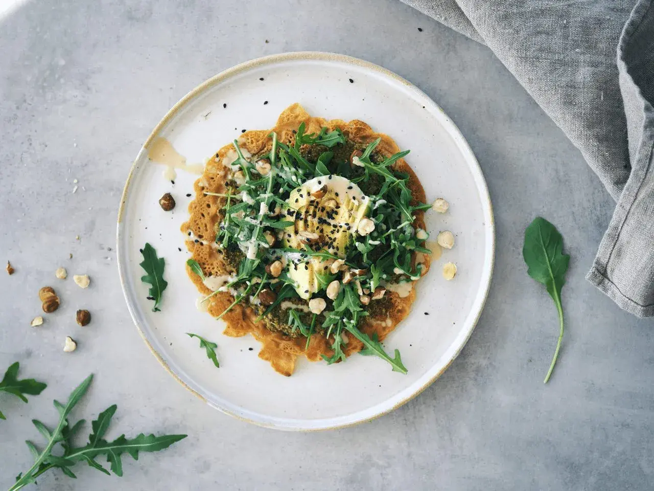 En vacker socca med ruccola, avokado och nötter. Ett härligt socca recept för en lätt lunch.