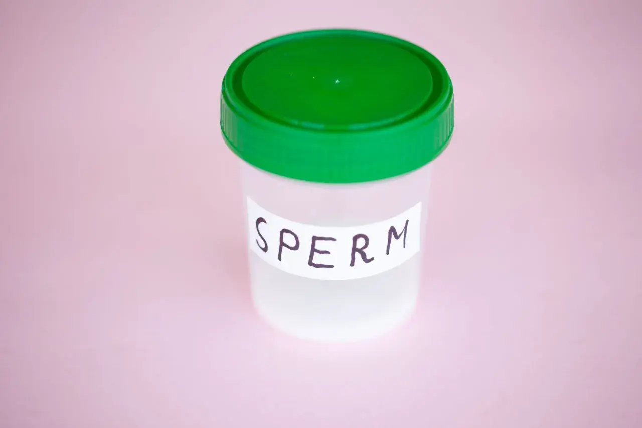 Contenitore con tappo verde, etichetta "SPERM". Potrebbe rappresentare un campione per analisi, legato a un'eiaculazione senza orgasmo.