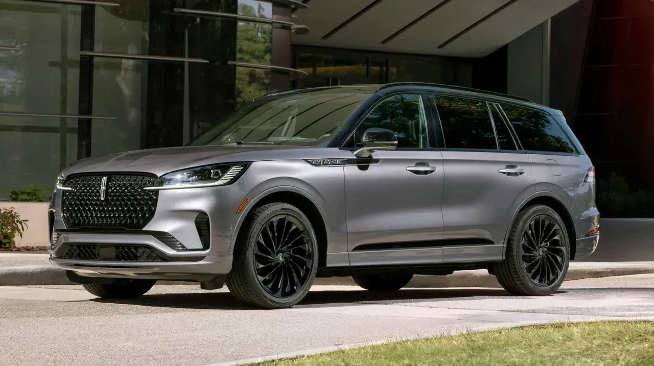 Szary Lincoln Aviator z czarnymi felgami stoi przed nowoczesnym budynkiem.