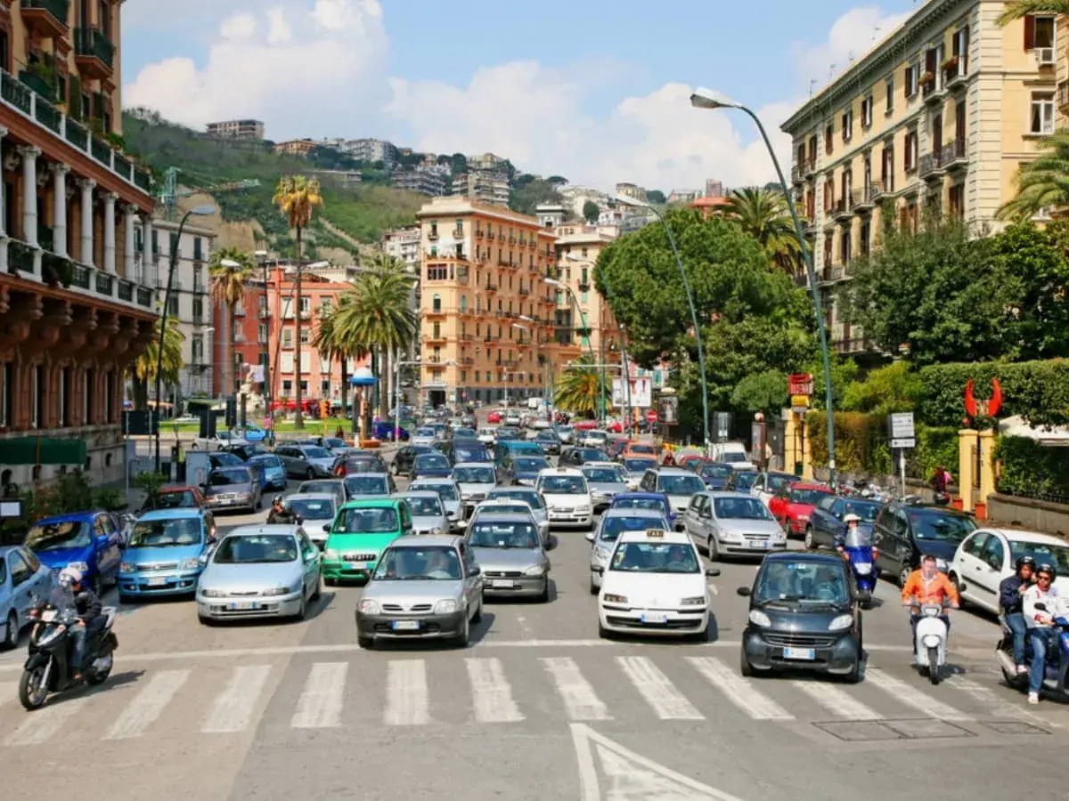 Busy street scene with cars and scooters, a typical day driving in Naples, Italy.