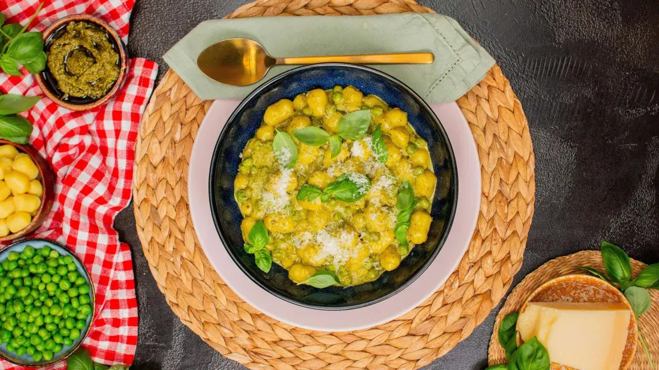 Gnocchi mit Erbsen und Basilikum-Pesto, garniert mit Parmesan. Ein köstliches Gericht, das Lust auf mehr macht.