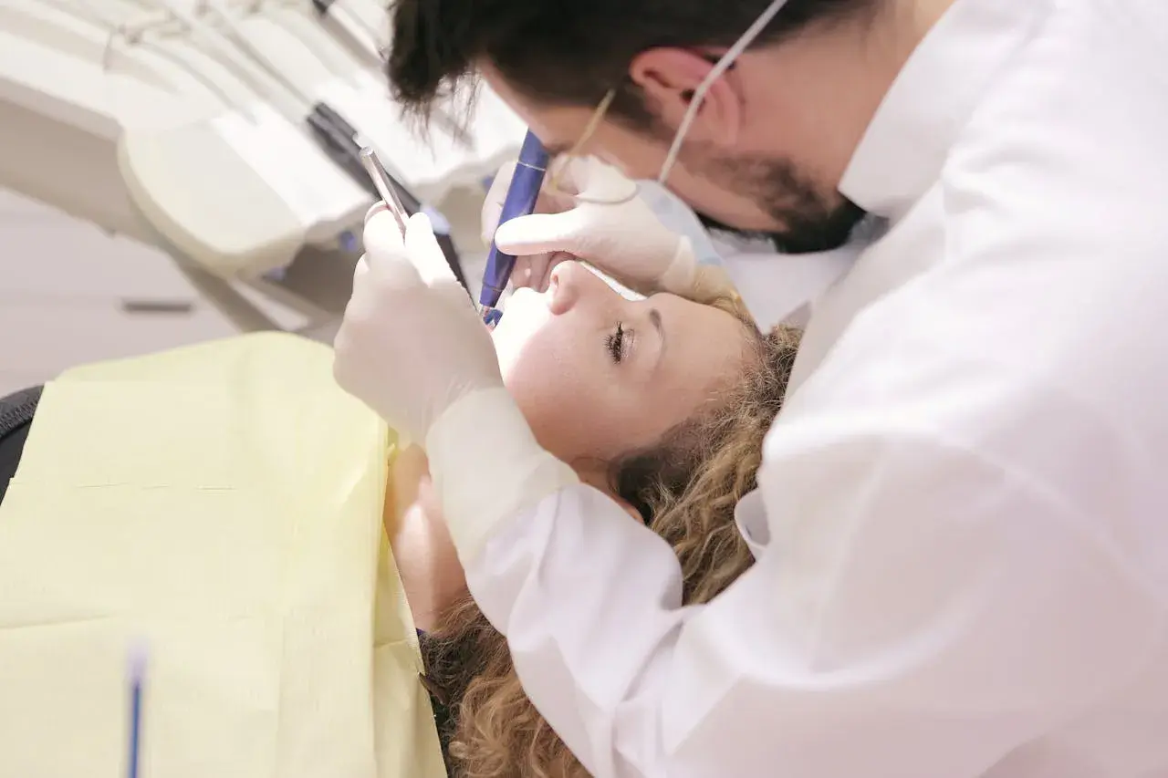 Dentysta bada zęby pacjentki, być może zmagającej się z problemem zębów Hutchinsona.