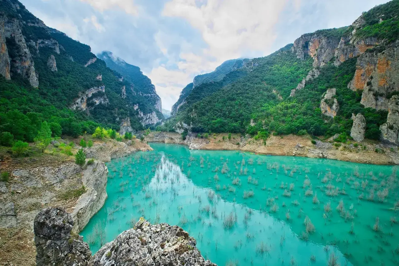 Impresionante cañón con agua turquesa y vegetación exuberante, ideal para rutas senderismo Catalunya.