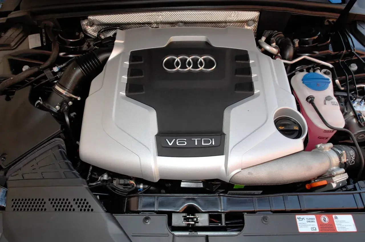 Silnik V6 TDI Audi, gotowy do pracy. Potężna jednostka napędowa z charakterystycznym logo czterech pierścieni.