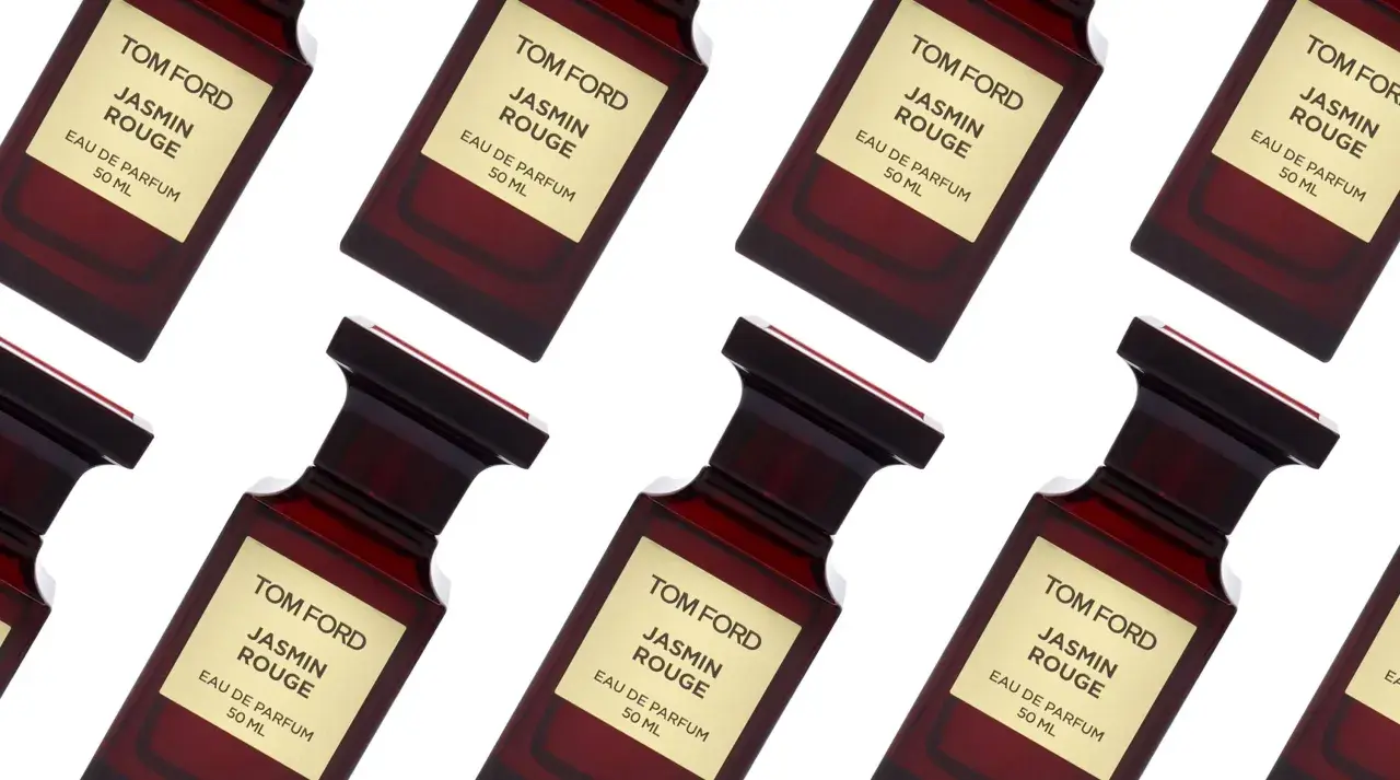 Wiele flakonów perfum Tom Ford Jasmin Rouge, każdy z charakterystyczną złotą etykietą i ciemnoczerwonym szkłem.