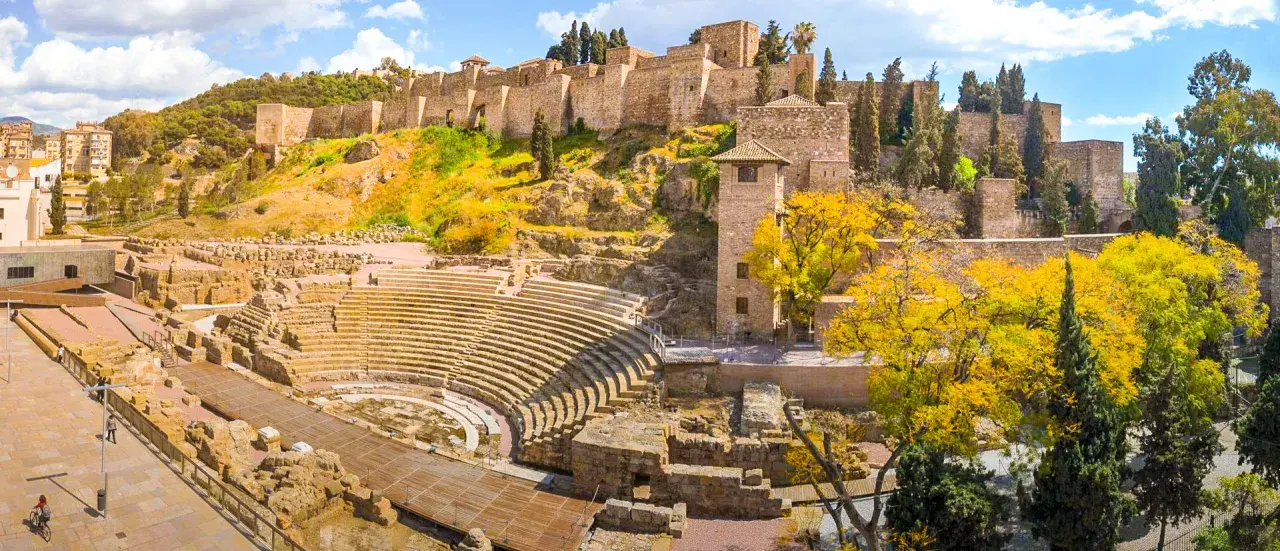Vestiges d'un théâtre romain et de l'Alcazaba, un site historique à visiter à Malaga, sous un ciel bleu éclatant.
