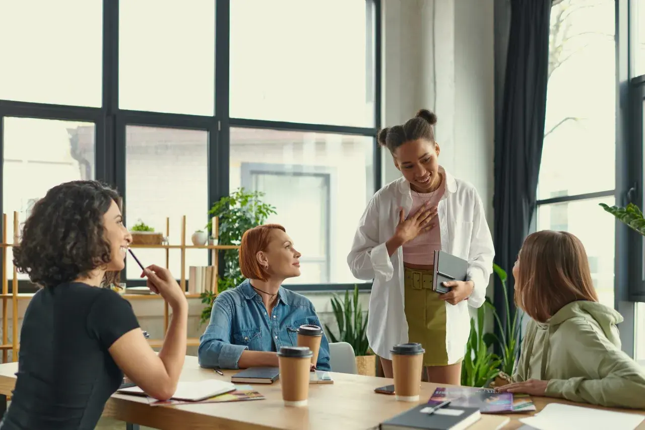 Grupo de mujeres en una reunión discutiendo cómo trabajar la autoestima.