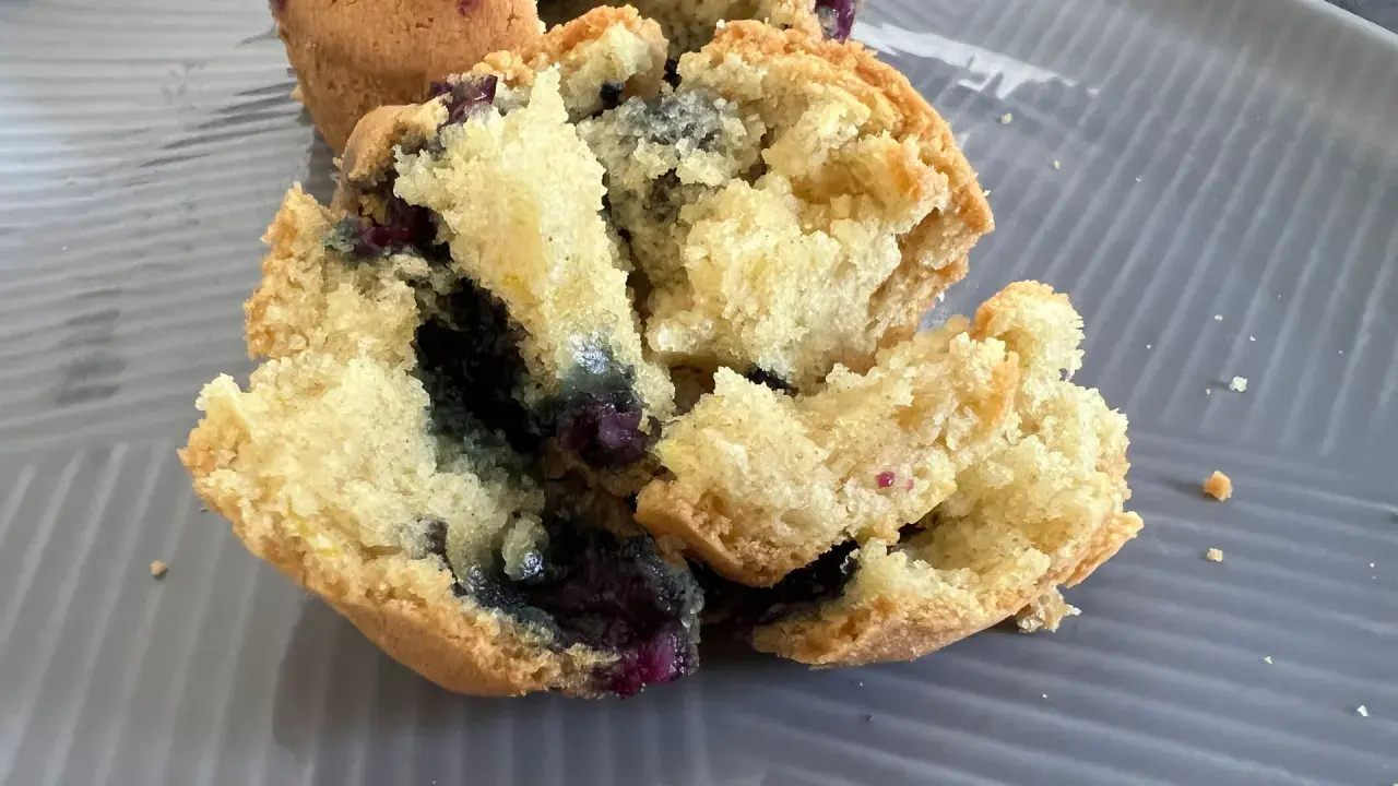 Muffin ai mirtilli appena sfornati nella friggitrice ad aria, con interno soffice e mirtilli succosi.