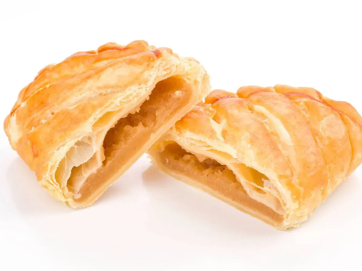 Pastelitos dorados y hojaldrados, cortados por la mitad, revelan un relleno dulce de ingredientes cabello de angel.