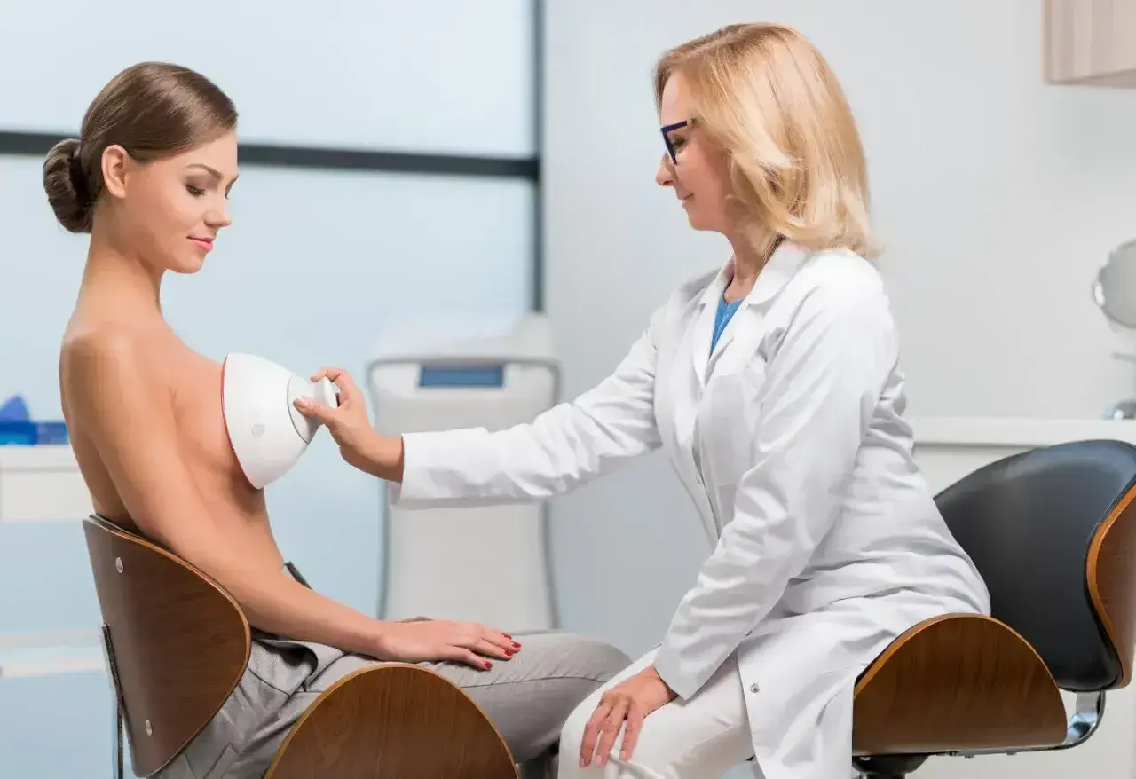 Lekarka wykonuje badanie USG piersi. Warto wykonać je w profesjonalnym gabinecie diagnostycznym.