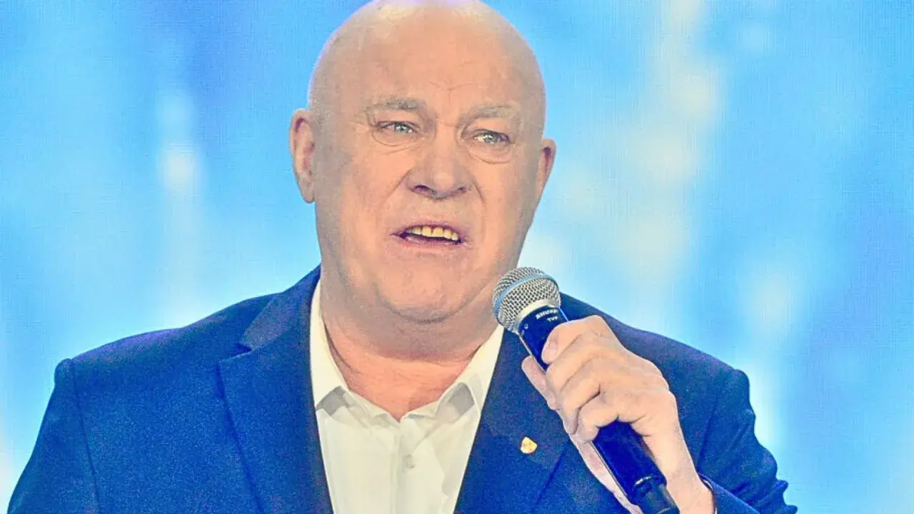 Łysy mężczyzna w garniturze trzyma mikrofon. Słychać jego głos: "Vox szczęśliwej drogi już czas!".