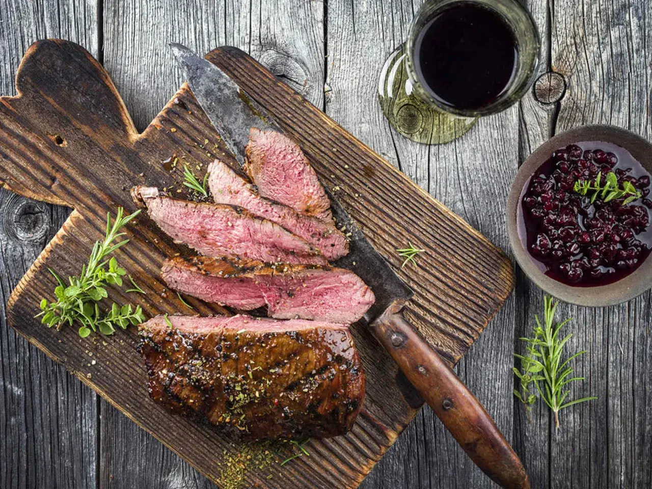 Skivad tagliata med rosmarin och en bärsås, perfekt till ett glas rött vin.