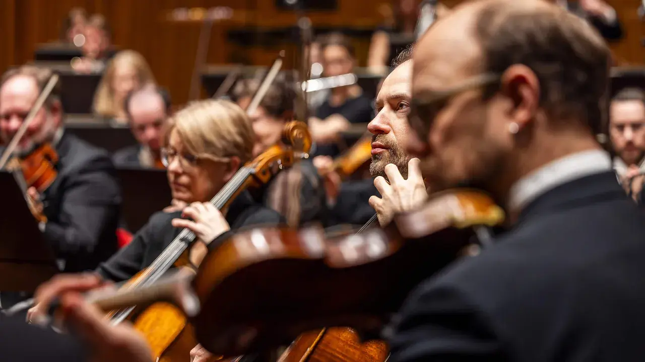 Musiker i orkester spelar cello och fiol. En del av Berwaldhallen program.