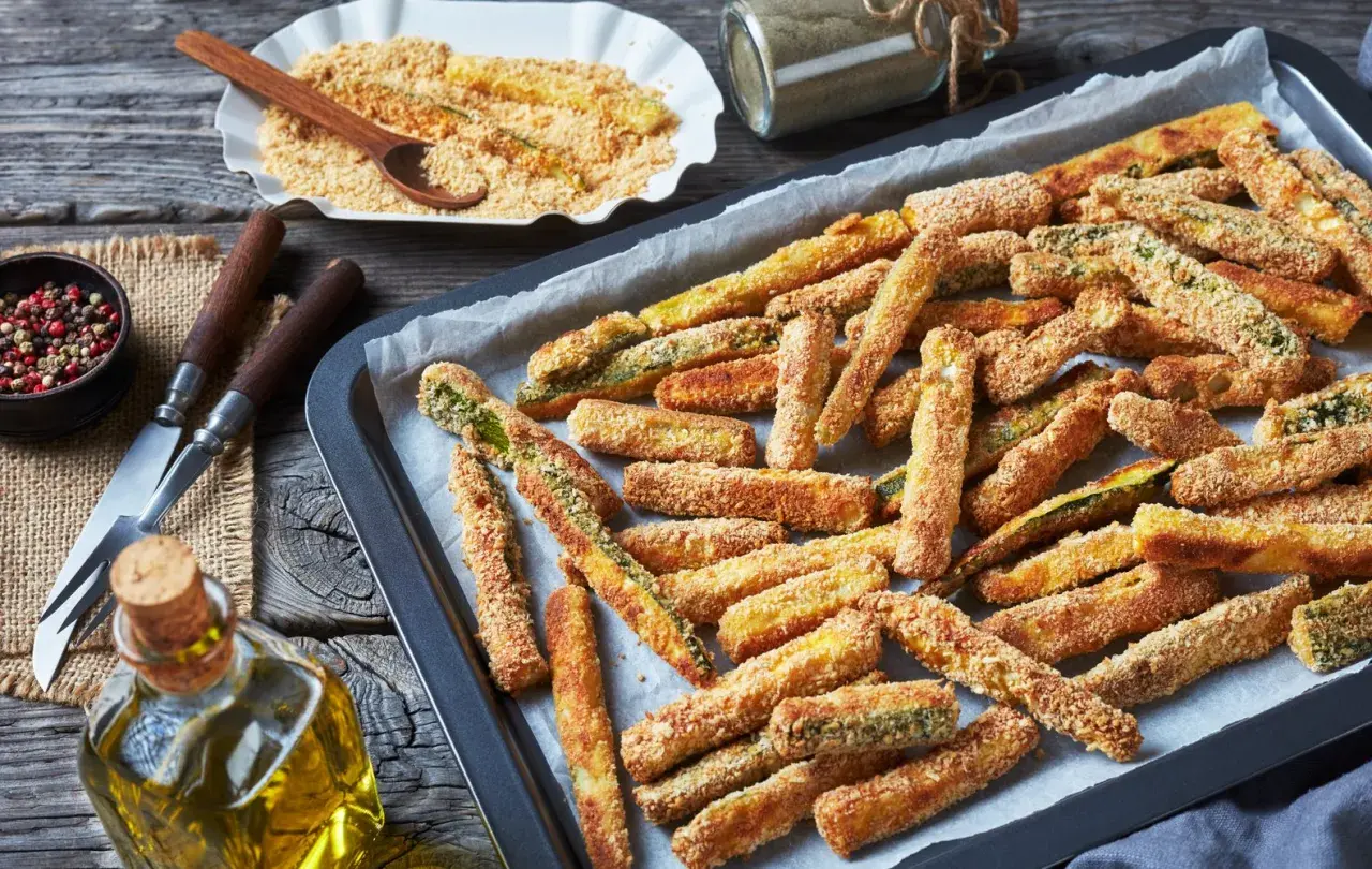 Bastoncini di zucchine al forno, dorati e croccanti, pronti per essere gustati.