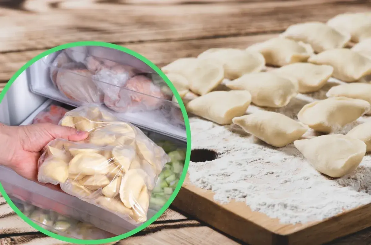 Ręka wkłada do zamrażarki worek z surowymi pierogami, obok leżą uformowane pierogi na desce.